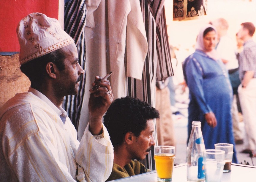 Men in a cafe watch the djemma el fna square in Marrakesh Morocco, photo by Greg Beaubien